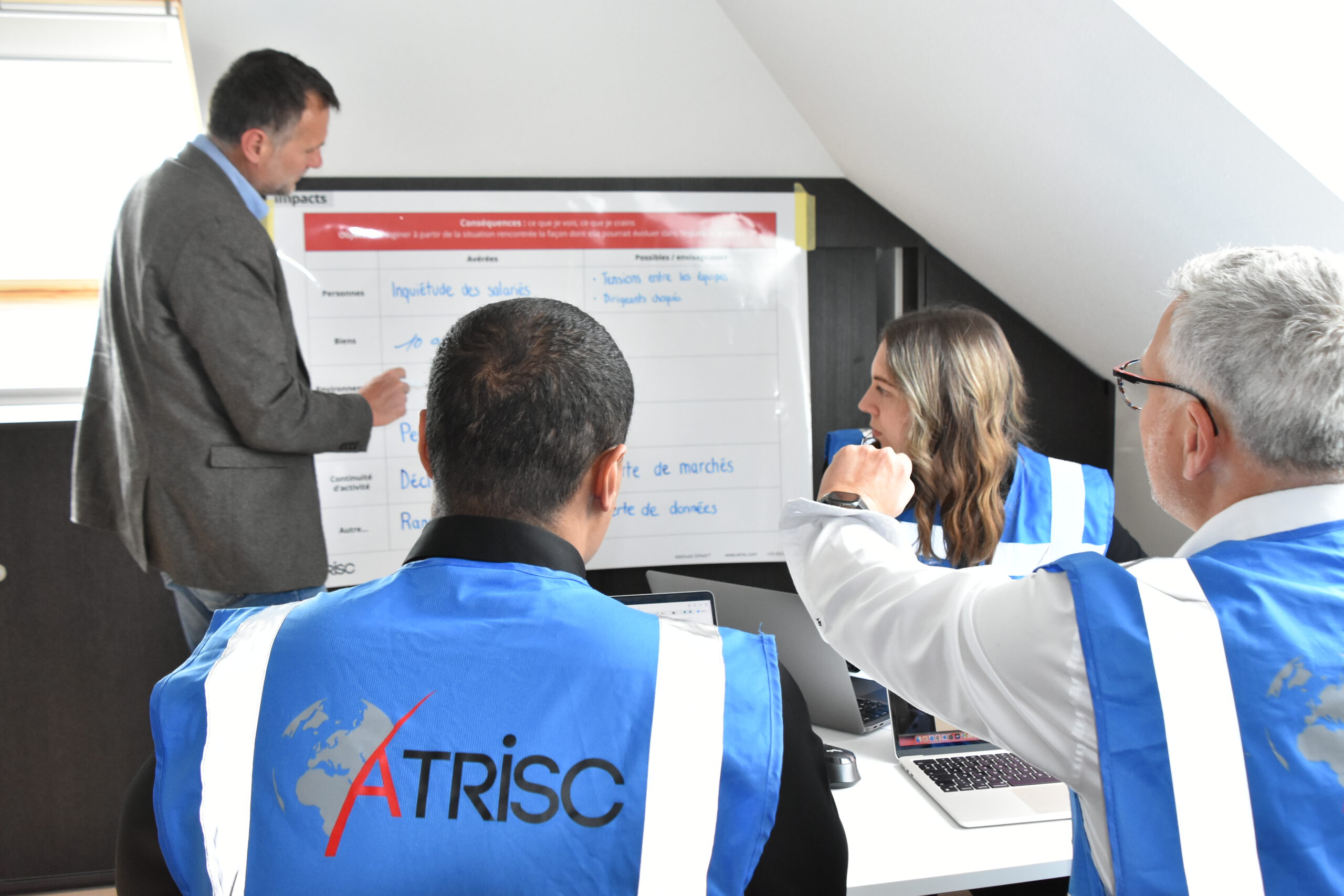 Experts ATRISC animant une formation en gestion de crise, en situation de travail collaboratif autour d’un exercice opérationnel.